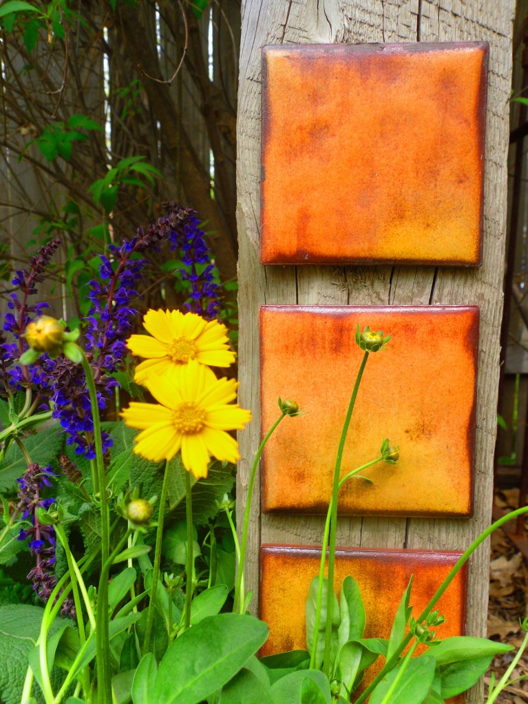garden drama tiles on a post